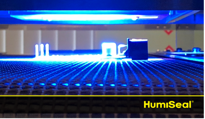 PCB with conformal coating passing through a UV light cure conveyor belt